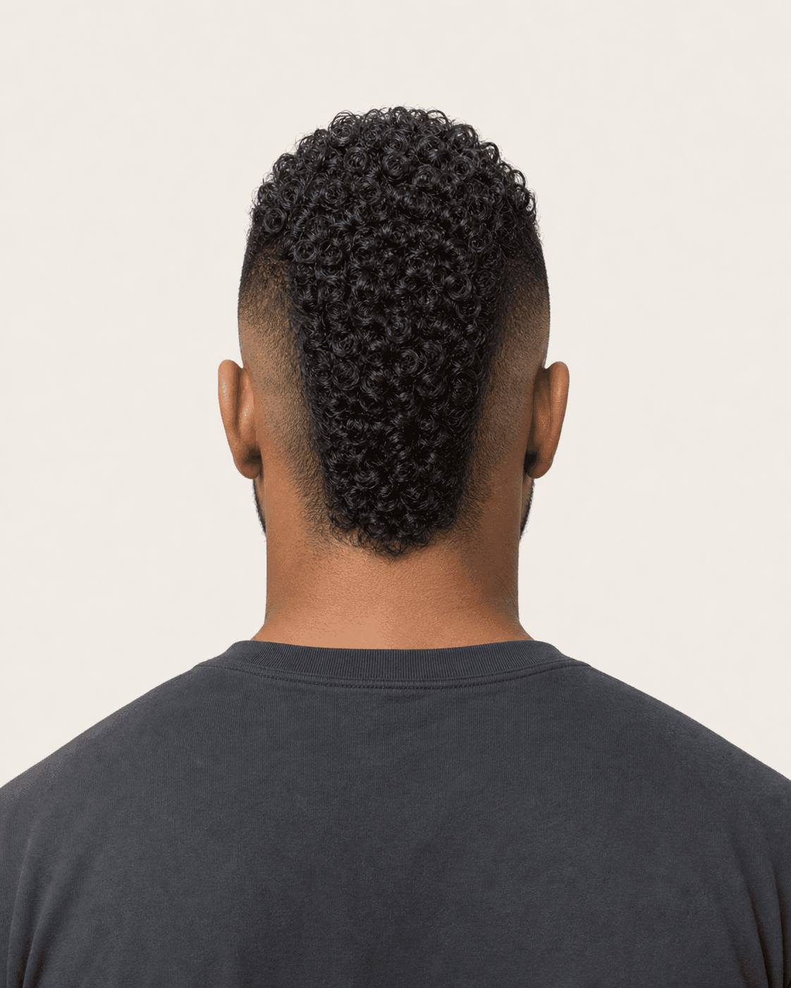 Rear view of a curly mohawk showing a narrow retained strip and symmetric burst fades