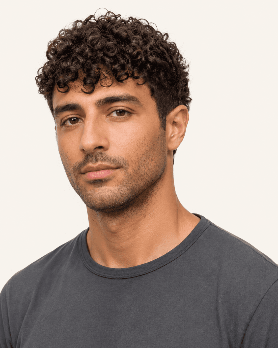 Three-quarter view of a curly fringe crop showing curl texture and taper
